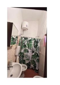a bathroom with a shower curtain with a toilet and a sink at Relax by the sea in Piriápolis