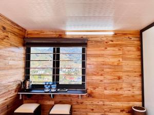 een raam in een kamer met een houten muur bij Sunflower Hotel Mộc Châu in Mộc Châu
