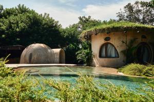 a house with a swimming pool in a garden at Nuanu Suites & Accommodations in Tanah Lot +28 photos