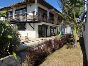 a house with a balcony and a palm tree at Villa Pasithéa in Sainte-Suzanne