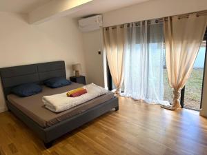 a bedroom with a bed and a large window at Villa Pasithéa in Sainte-Suzanne +5 photos