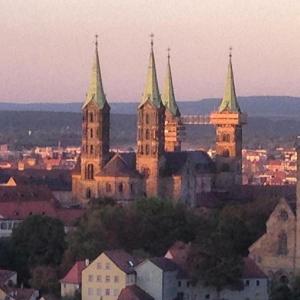 a large church with towers in a city at sunset at Garten Apartment für Hundefreunde umzäunt Souterrain in Hirschaid +12 photos