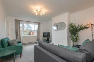a living room with a couch and a tv at Spacious 5 Bed Close to Elland Road, First Direct Arena & Headingley Stadium in Roundhay