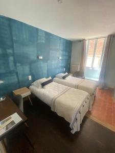 Postel nebo postele na pokoji v ubytování Hôtel des Cymaises