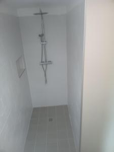 a white bathroom with a cross on the wall at La garçonnière in Gesvres