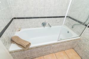 a white bath tub with a towel sitting on it at Relaxing Seaside Escape at 2 Perissa in Ballito +33 photos