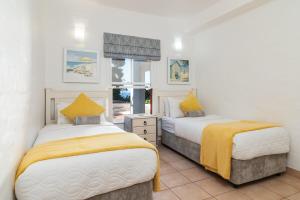 a bedroom with two beds and a window at Relaxing Seaside Escape at 2 Perissa in Ballito