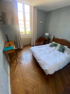 Postel nebo postele na pokoji v ubytování Hôtel des Cymaises