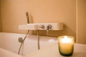 a candle sitting on a bath tub with a sink at La Casa Miguel in Avignon +10 photos