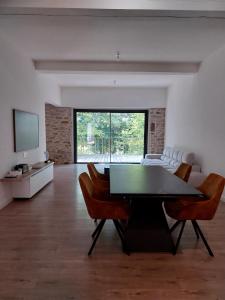 ein Wohnzimmer mit Tisch und Stühlen und einem Fernseher in der Unterkunft Maison moderne proche de la gare de Vannes in Saint-Avé