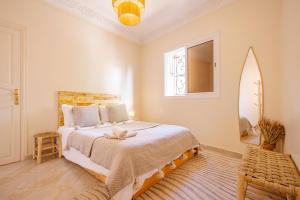 a bedroom with a large bed and a window at Sable Beach Surf Camp & Hostel Tamraght in Tamraght Ouzdar
