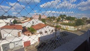 a view through a wire fence of roofs of buildings at Apto em Sorocaba Prox Prefeitura e Parque das Aguas in Sorocaba
