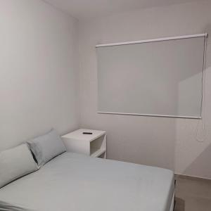 a white bedroom with a bed and a mirror at Apto em Sorocaba Prox Prefeitura e Parque das Aguas in Sorocaba