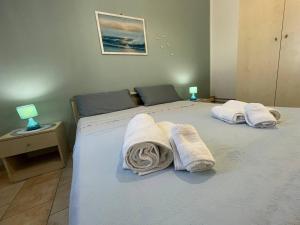 una camera da letto con due letti con asciugamani sopra di Casa Vacanza ORO BLU DEL SALENTO a Torre San Giovanni Ugento