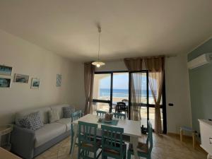 un soggiorno con un divano e un tavolo di Casa Vacanza ORO BLU DEL SALENTO a Torre San Giovanni Ugento