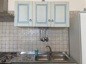 una cucina con lavello e armadi blu di Casa Vacanza ORO BLU DEL SALENTO a Torre San Giovanni Ugento Altre 20 foto