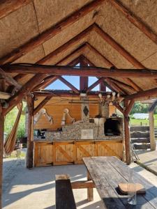 a wooden pavilion with a table and a stove at La Ionicã Rozavlea MM in Rozavlea