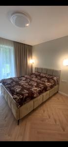 a bedroom with a large bed in a room at Luxury Šarli Apartment Nemirsetos parke in Palanga