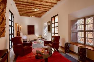 a living room with a bed and a table and chairs at Dar Syada Boutique Hotel Marrakech in Marrakech