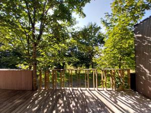 eine Holzterrasse mit einem Baum im Hintergrund in der Unterkunft Maison moderne proche de la gare de Vannes in Saint-Avé