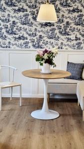 a table with a vase of flowers on it in a room at Villa Autentic in Juodkrantė