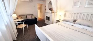 a bedroom with a bed and a couch and a fireplace at Villa Autentic in Juodkrantė +9 photos