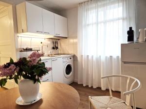 a kitchen with a vase of flowers on a table at Villa Autentic in Juodkrantė