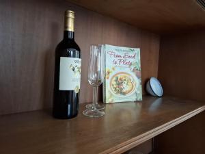 a bottle of wine and a glass on a shelf at Casa vacanza PerlaBlu in Fezzano +16 photos