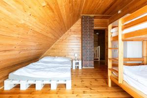 a room with two beds in a wooden cabin at Korsarz in Rusinowo
