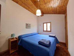 a bedroom with a blue bed with a wooden ceiling at Casa vacanza PerlaBlu in Fezzano