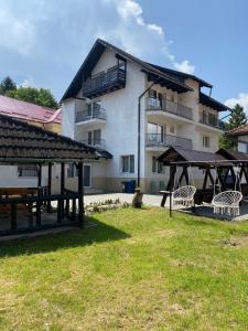 a building with a picnic area in front of it at Pensiunea Carina in Bran