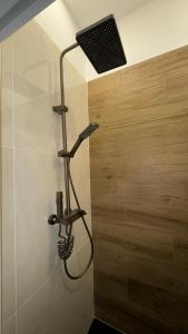 a shower in a bathroom with a light on the wall at Maisonnette climatisée avec jardin proche océan in Saint-André-de-Lidon