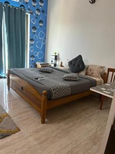 a large bed in a bedroom with a blue wall at Aaiyana room stay in Chengalpattu