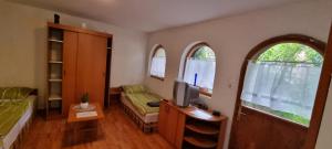 Una habitación con una cama y un escritorio con televisión. en Gergely Apartman, en Pálosvörösmart
