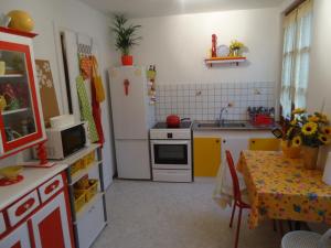 Una cocina con un refrigerador y una mesa dentro. en La Tour Enchantée, en Ribeauvillé