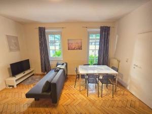 a living room with a couch and a table at City Heart Apartment Innsbruck in Innsbruck