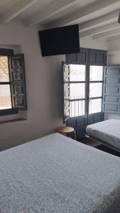 a bedroom with two beds and two windows at Villa Beso Casa Rural in Otívar +65 photos