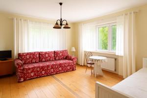 a living room with a red couch and a table at Dujawica in Ząb