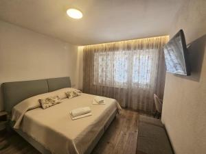 a small bedroom with a bed and a window at Apartments Lusi in Brela