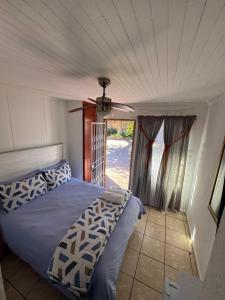 una camera da letto con un letto e un ventilatore a soffitto di CenturionSleep&Go a Centurion