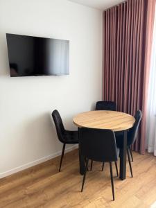 a table and chairs in a room with a television at Apartament Grojec in Grojec