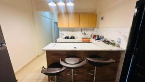 a kitchen with three stools at a kitchen counter at Regina resort Ain soghna in Ain Sokhna +3 photos