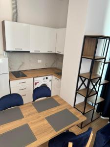 a kitchen with a table and chairs and a shelf at Arber Premium Apartment in Durrës