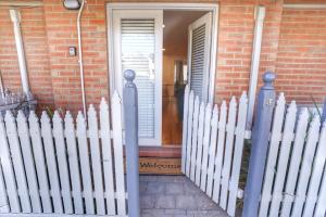 a white picket fence in front of a house at Cosy Ground Floor Walk to Adelaide Oval, City, Zoo & More in Adelaide +7 photos