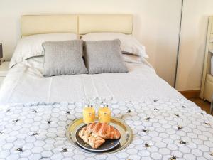 a tray of food on a bed with two glasses of orange juice at Sheep's View Cottage in Eastbourne +26 photos
