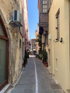 an alley in an old town with buildings and plants at Sea Path VII Rethymno old town luxury Maisonette steps to beach in Rethymno Town
