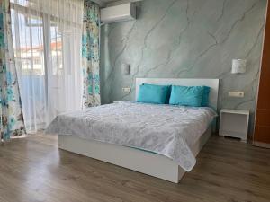 a bedroom with a large bed with blue pillows at Къща за Гости Морска звезда in Ahtopol +40 photos