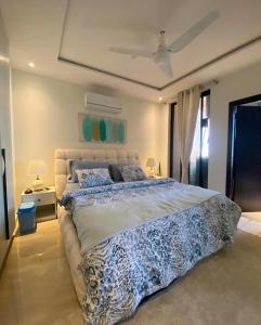 a bedroom with a large bed with a blue and white comforter at Cozy one bed in Gulberg in Lahore +39 photos