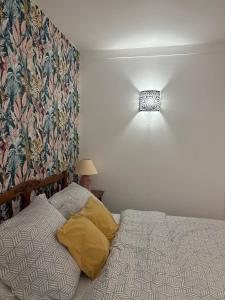 a bedroom with a bed and a light on the wall at Appartements des Compagnons in Val de Reuil