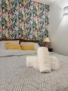 a bedroom with a bed with a tropical wallpaper at Appartements des Compagnons in Val de Reuil